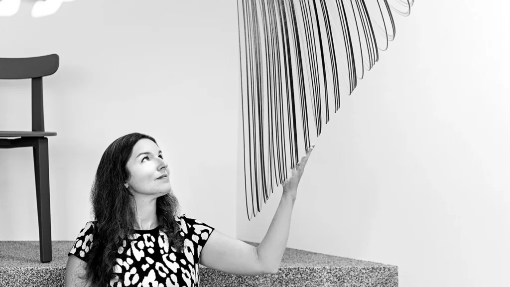 The designer Zsuzsanna Horvath poses with her striking suspension lamp, Illan